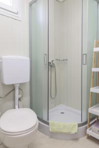 a bathroom with a toilet and a glass shower at Mobile Homes Camping Biograd in Biograd na Moru
