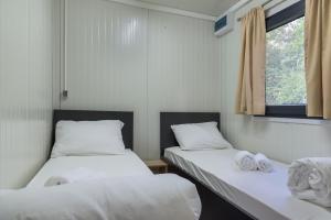 two beds in a small room with a window at Mobile Homes Camping Biograd in Biograd na Moru