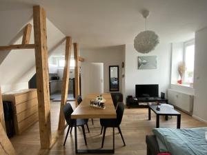 a living room with a table and a room with a bed at Carpe diem in Strasbourg