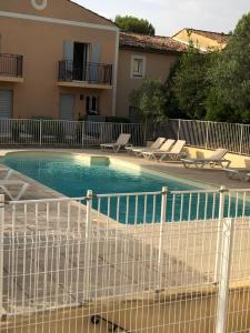 馬勒莫爾的住宿－Le Cigalou，一座房子旁的游泳池,设有白色的围栏