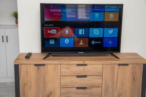 una TV a schermo piatto seduta sopra un armadio in legno di OceanView Villa a Discovery Bay