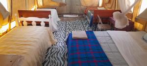 a bedroom with two beds and a zebra pattern at Lookout homestay in Sekenani