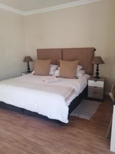 a bedroom with a large white bed with two lamps at Jenvey House Selfcatering Apartments & BnB in Port Elizabeth