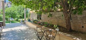 un patio con mesa, sillas y un árbol en Luxury House since 1960, en Nazaret