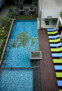 a pool with a tree in the middle of a house at Hotel Santika Mataram in Mataram