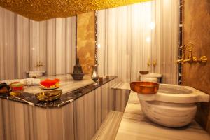 a bathroom with a tub and a sink in it at Old Town Point Hotel & Spa Antalya in Antalya