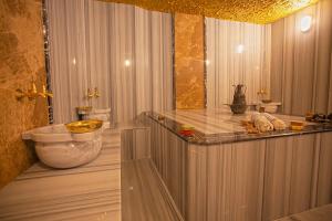 a bathroom with a tub and a sink in a room at Old Town Point Hotel & Spa Antalya in Antalya