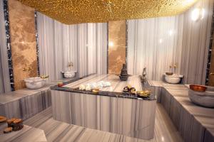 a room with a bath tub with sinks and toilets at Old Town Point Hotel & Spa Antalya in Antalya