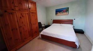 een slaapkamer met een bed en een grote houten kast bij SPERLONGA VILLETTA SUL MARE CON ACCESSO ALLE SPIAGGIA POSIZIONE ESCLUSIVA in Sperlonga