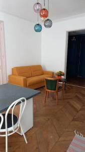 ein Wohnzimmer mit einem Sofa, einem Tisch und Stühlen in der Unterkunft A 2 pas du marché in Saint-Jean-dʼAngély