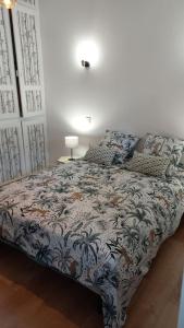 a bedroom with a bed with a blue and white comforter at A 2 pas du marché in Saint-Jean-dʼAngély