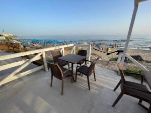 een tafel en stoelen op een balkon met uitzicht op het strand bij SPERLONGA VILLETTA SUL MARE CON ACCESSO ALLE SPIAGGIA POSIZIONE ESCLUSIVA in Sperlonga