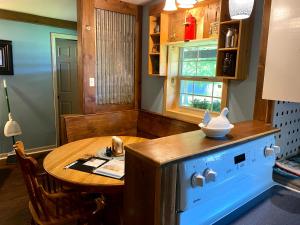 eine Küche mit einem Holztisch, einem kleinen Tisch und einem Herd in der Unterkunft Bunkhouse Farm Stay in Fort White