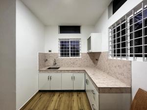 a kitchen with white cabinets and a sink at Tess Holistay Fort Kochi in Fort Kochi