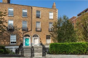 a brick building with a blue door in front at Spectacular 2 Bedroom Apartment with Sunny Garden & Terrace in Dublin