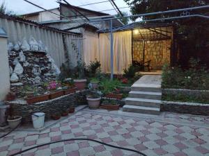 a garden with a patio with potted plants and a fence at Uyut house Osh in Osh