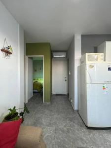 a room with a white refrigerator and a bedroom at Departamento en San Juan in San Juan