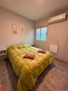 a bedroom with a large yellow bed with two pillows on it at Departamento en San Juan in San Juan