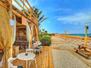 restauracja ze stołami i krzesłami przy plaży w obiekcie Villa for Rent @ El Fanar Resort (Zaafarana-Sokhna) w mieście Ajn Suchna