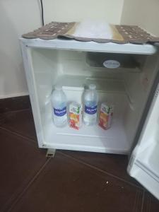 an open refrigerator with bottles of water and yogurt at Malak Guest House in Cairo