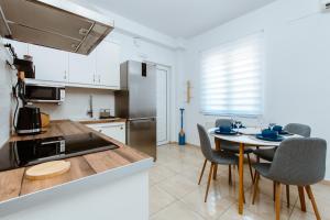 cocina y comedor con mesa y sillas en Harmony Apartments, en Kato Daratso