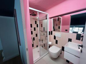 a pink bathroom with a toilet and a shower at Loft Deluxe centralissimo-Antica Vetreria in San Benedetto del Tronto +23 photos