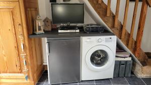 a tv sitting on top of a washing machine at Le Jardin des Murmures in Honfleur