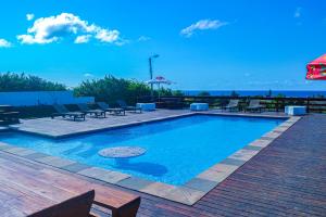 a large swimming pool with chairs and a table at Ponta View Hotel in Ponta do Ouro