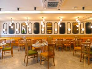a restaurant with tables and chairs and mirrors at Old Town Point Hotel & Spa Antalya in Antalya