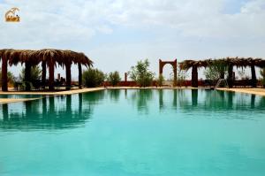 a large swimming pool with a slide in the middle at Kasbah Du Berger & Piscine in Merzouga