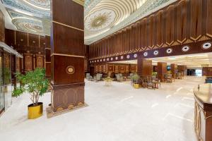 een lobby van een gebouw met tafels en stoelen bij WA Hotel in Jeddah