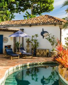 a house with a swimming pool in front of a house at Vila da Santa Hotel Boutique & Spa in Búzios