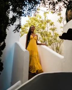 a woman in a yellow dress holding a surfboard at Vila da Santa Hotel Boutique & Spa in Búzios +27 photos