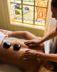 une femme recevant un massage du dos d'un thérapeute dans l'établissement Vila da Santa Hotel Boutique & Spa, à Búzios