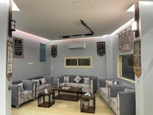 a living room with two couches and a tv at Aya Hostel in Al Madinah