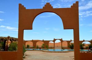 un arco en el patio de una mezquita en el desierto en Kasbah Du Berger & Piscine en Merzouga