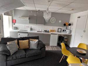 a living room with a couch and a kitchen at Berkswell Holiday Apartments in Blackpool