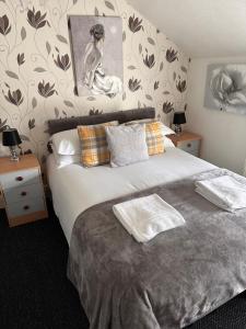 a bedroom with a bed with a painting on the wall at Berkswell Holiday Apartments in Blackpool