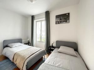 1 dormitorio con 2 camas y ventana en The Patio By Disney, 3 chambres, 2 salles de bain, en Lagny