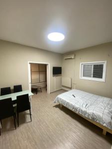 a bedroom with a bed and a desk and a television at Teper Apartment in Bat Yam