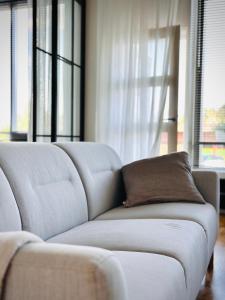 a living room with a white couch with a brown pillow at Lomahuoneisto Wanha Vääksy in Vääksy