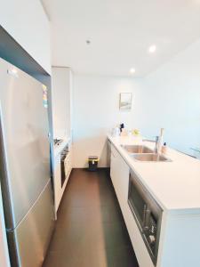 uma cozinha com um lavatório e um frigorífico em Comfy & Bright 1 Bed Apt Olympic em Sydney