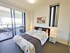 um quarto com uma cama e uma varanda em Comfy & Bright 1 Bed Apt Olympic em Sydney