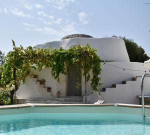 ein Haus mit einem Pool vor einem Gebäude in der Unterkunft Terre d'amore - For couples in Ostuni