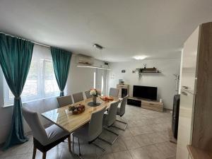 a dining room with a table and chairs and a television at Villa Green Hill, Cista Velika, Imotski in Omiš