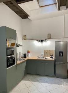 - une cuisine avec des placards verts et un réfrigérateur dans l'établissement Atypique - Centre historique - Appartement 2 chambres, à Bourges
