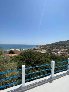 a blue and white fence with the ocean in the background at Karfas Seascape in Chios