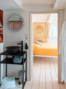 een badkamer met een wastafel en een slaapkamer met een bed bij Bed and breakfast Jan in Edam