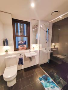 uma casa de banho com um WC, um lavatório e um chuveiro em Comfy & Bright 1 Bed Apt Olympic em Sydney