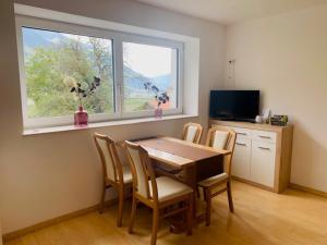 una sala da pranzo con tavolo, sedie e finestra di Alpenrose a Silandro